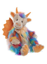 A rainbow multicoloured fluffy dragon plush toy sits upright against a white background, featuring orange horns, wings, claws, and a sheer ribbon bow around its neck.