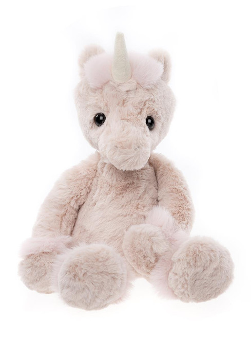 A soft, plush unicorn teddy bear in pale beige/blush tones sits upright against a white background, featuring a silvery horn, small round ears, shiny black eyes, and oversized paws.