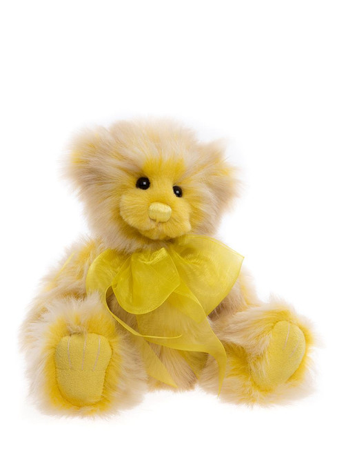 A yellow plush teddy bear sits upright against a white background, wearing a bright yellow organza ribbon bow tied around its neck.