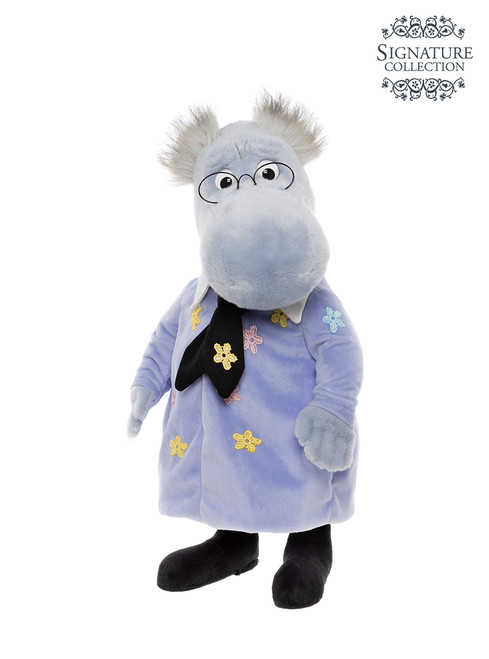 A grey hippopotamus plush toy stands upright, wearing a lavender floral dress, black bow tie, glasses, and black shoes, with grey tufted hair.