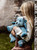 A blue-grey Charlie Bears plush toy combining goat features (curved horns, pointed ears) with butterfly wings, sitting upright against a white background.