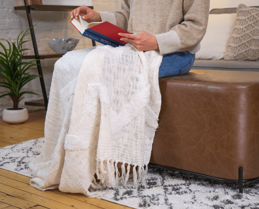 Person reading on Wovenbyrd Ottoman