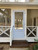 White-painted wood screen door with 3/4 solid panel design installed on a porch entryway