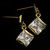 Gold tone cubic zirconia dangle earrings with a diamond shaped stone hanging from a diamond shaped post CZ28