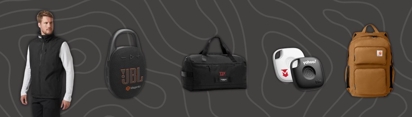 Model wearing a black vest beside a portable speaker, a duffel bag, tracking tags, and a tan backpack.