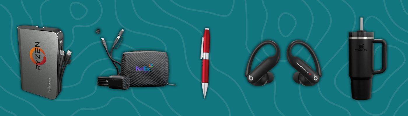 MyCharge portable power bank, Hypergear travel charging kit, red Cross rollerball pen, Beats earbuds, and Stanley tumbler on teal background.
