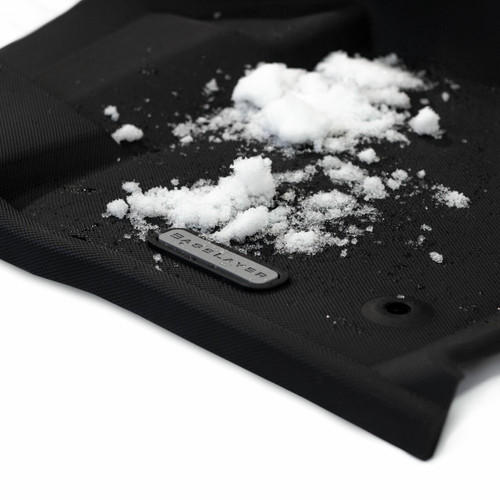 Edge view of the 2015 - 2025 front BaseLayer Ford F-150 Custom-Fit Floor Liners with snow on it with gray logo