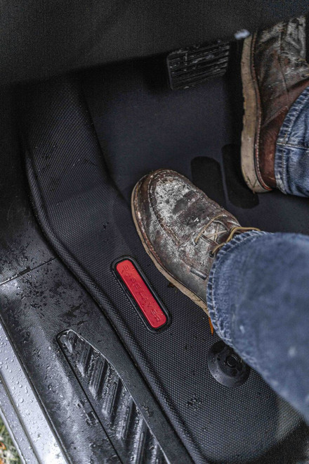 Driver's feet on BaseLayer custom-fit driver side floor liner for the 2020+ Chevy Silverado HD Crew Cab with red logo