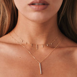Glistening in 14k gold, this dangle necklace showcases diamond-studded drop bar pendants on a delicate cable chain, perfect when paired with the matching diamond bar necklace for a radiant ensemble on a clear-skinned Puerto Rican model.