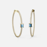 Crafted in 18k yellow gold, a side view of these 45mm inside-out Blue Topaz Hoop Earrings that elegantly reveal the beauty of a topaz stone.