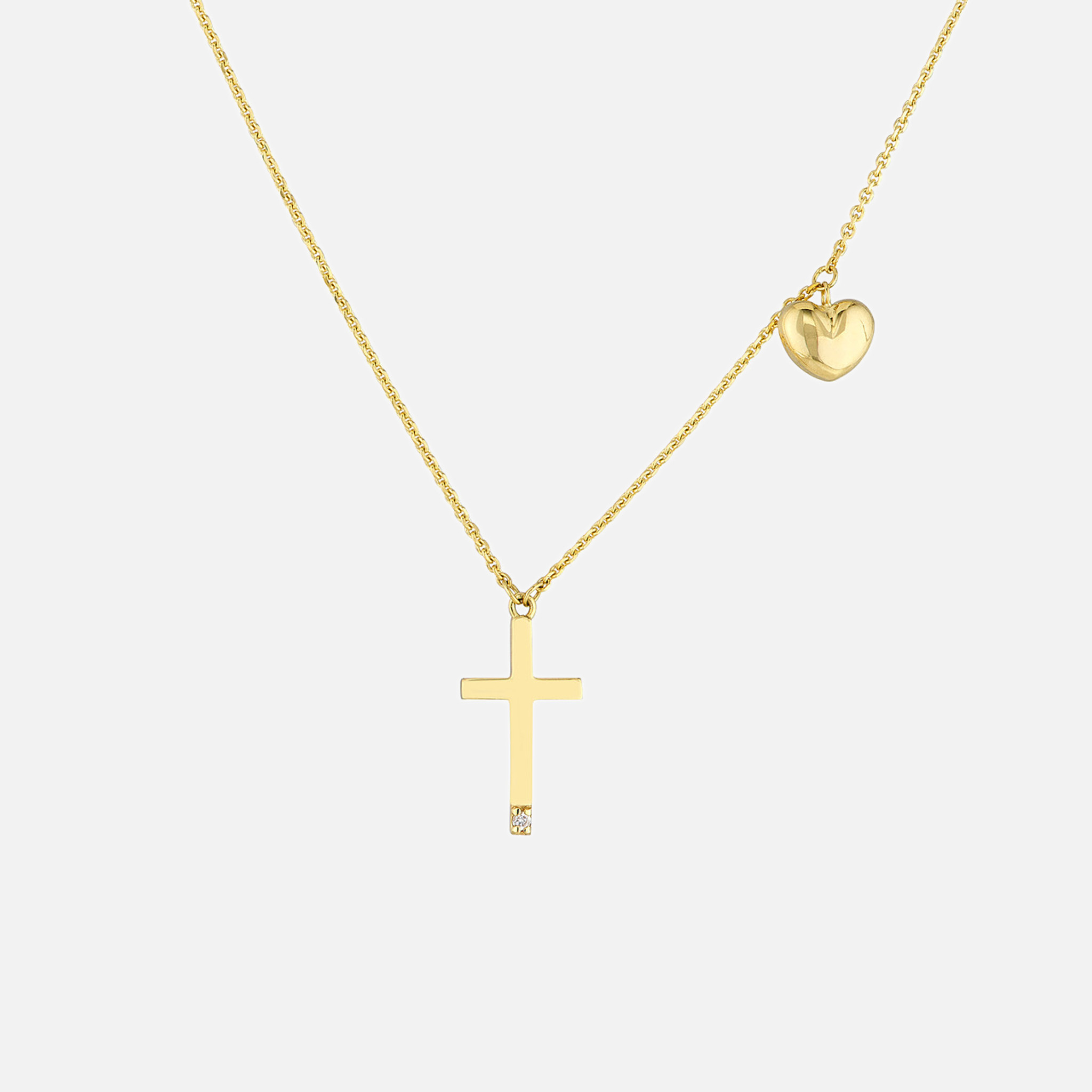 Sleek 14k gold tiny diamond cross necklace with a solitaire diamond-encrusted cross and a charming puff heart.