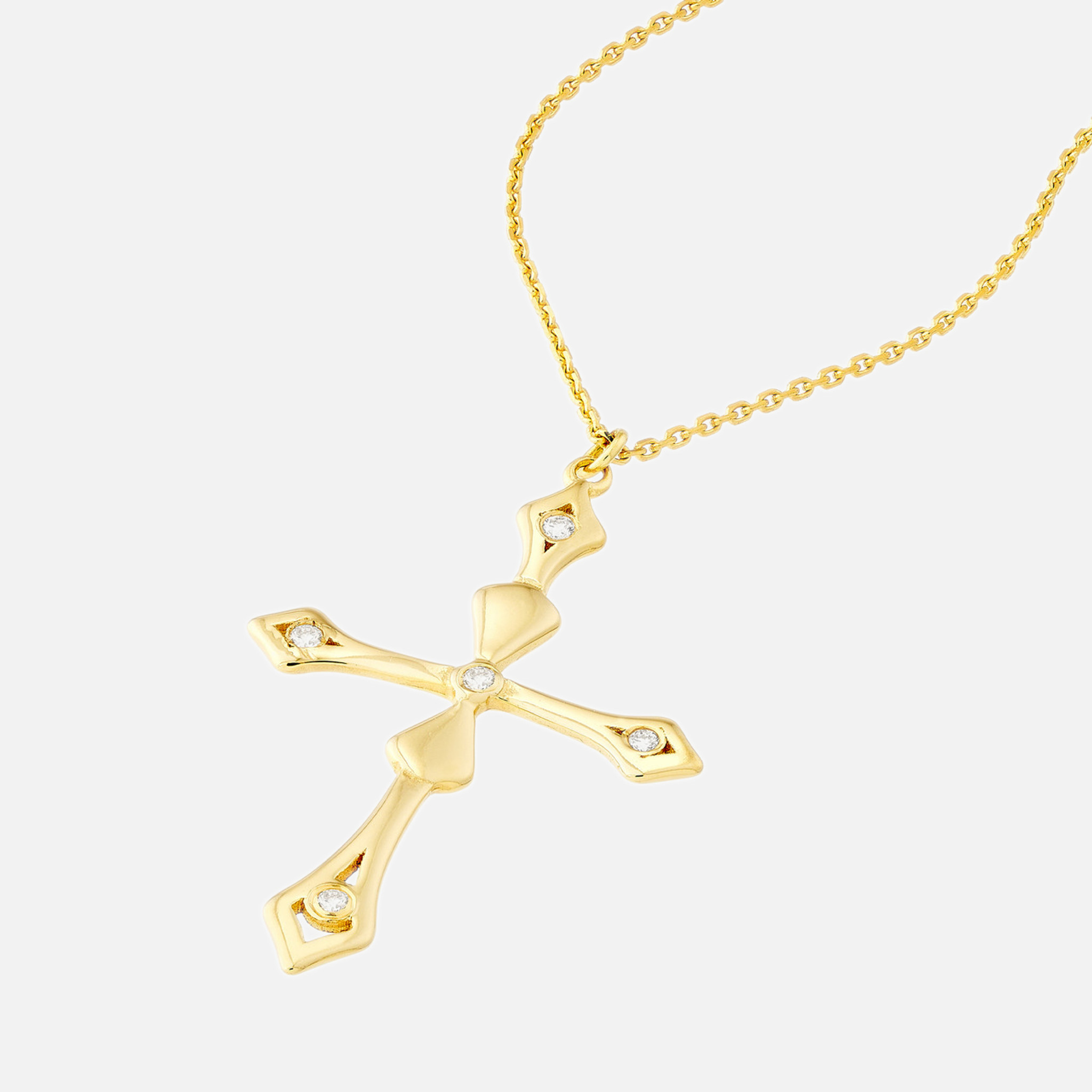 Close-up view of 14k gold diamond cross pendant necklace featuring four dainty white diamonds and a sculptural cross on a bold cable chain.