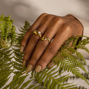 The Gold Panther Ring encircles the finger of a Brown-Skinned Model's hand.