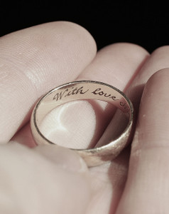 Gold ring with inscription 'With Love' elegantly engraved on its surface.