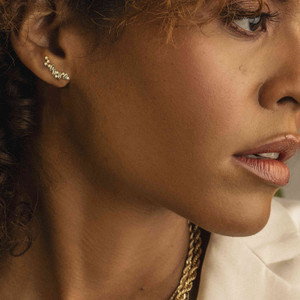 Adorning elegance on a dark-skinned Puerto Rican model, the 18k Gold Diamond Ear Crawler Earrings feature a beautiful balance between baguette and round cut diamonds, securing the most talked-about gold accessory.