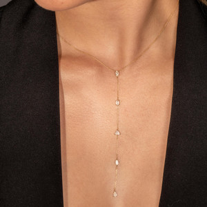 Female model showcasing the 18k gold diamond lariat necklace, the perfect statement piece that gracefully enhances her neck.