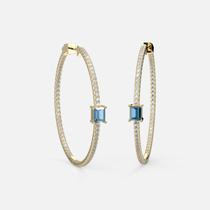 Crafted in 14k yellow gold, a side view of these 45mm inside-out Blue Topaz Hoop Earrings that elegantly reveal the beauty of a topaz stone.