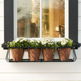 Heatherbrook window box with 4 terracotta pots planted with flowers and mounted to home with black shutters