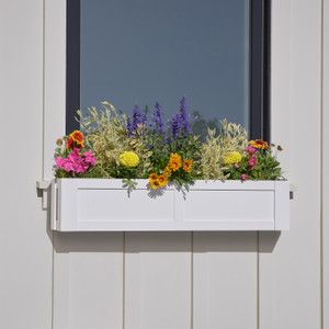 Solera window box mounted under a window with multi color flowers Solera window box mounted under a window with multi color flowers