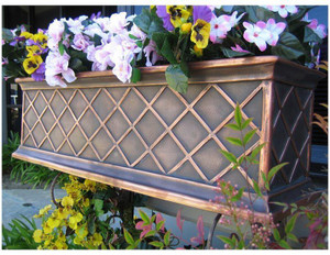 Copper ArmoreCoat La Fleur Railing Planter, decorative copper-colored metal planter with a diamond lattice design filled with colorful flowers and green foliage.