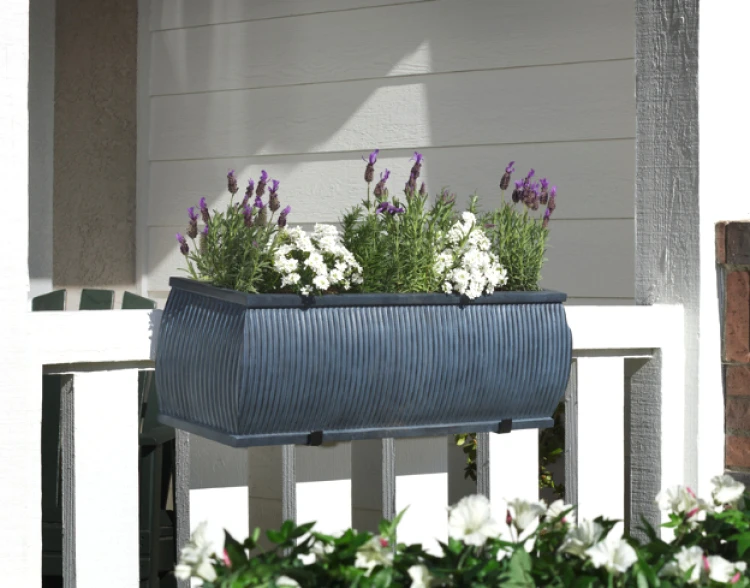 Barrel Fiberstone Railing Planter on a white wood railing filled with purple and white flowers
