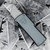 Grey anodized aluminum CobraTec OTF knife displayed with cut metal shavings, precision-engineered 6061-T6 handle, interchangeable standard utility blades