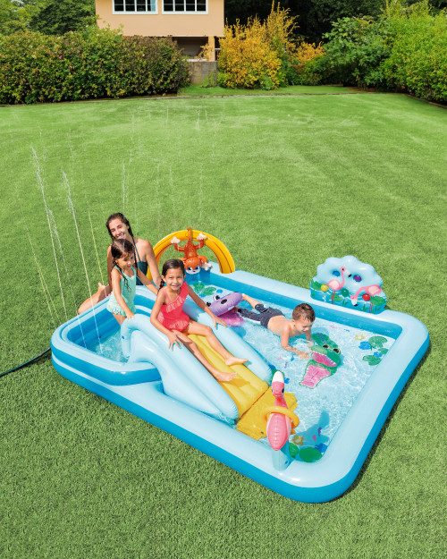 Family Standing In Plastic Swimming Pool With Fishing Equipment