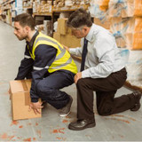 Man in high vis squatting to lift a box in a warehouse