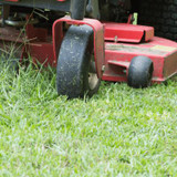 Mulcher attachment being used on bright healthy grass.