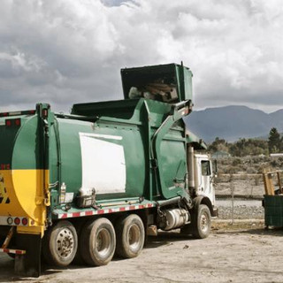 Garbage truck emptying skip bins.