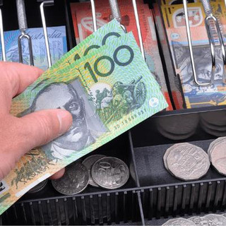 A person handling money at a cash register.