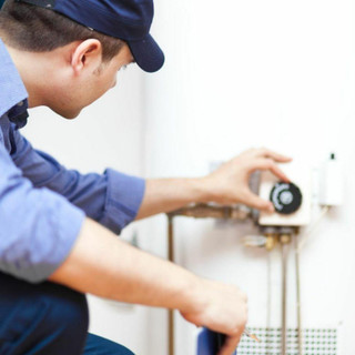 A worker adjusting a dial on electrical plumbing