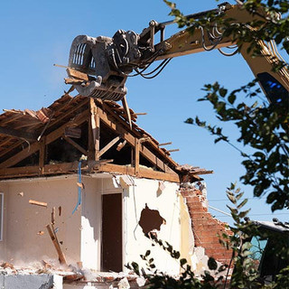 Excavator in demolition of home residential building