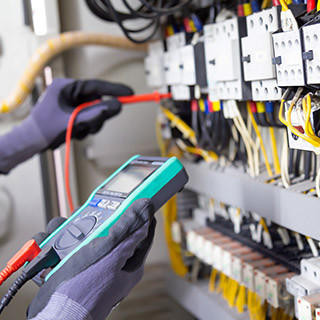 Electrician engineer tests electrical installations and wires on relay protection system