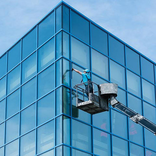 Washer washing the windows of modern skyscraper