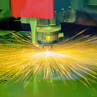 Close-up of the CNC laser cutting machine cutting the metal plate with the sparking light.