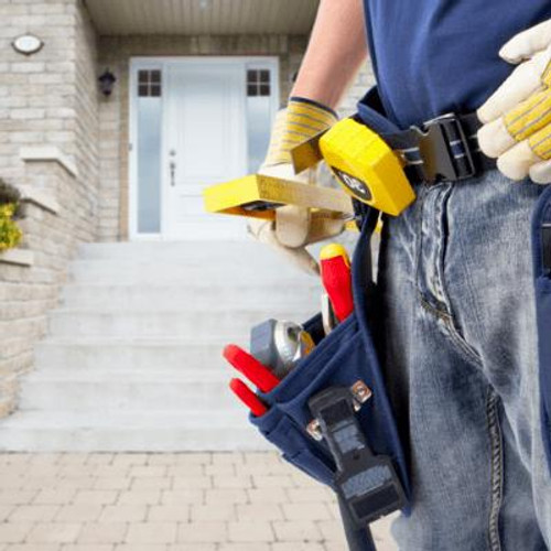 Workman with tool belt in front of house