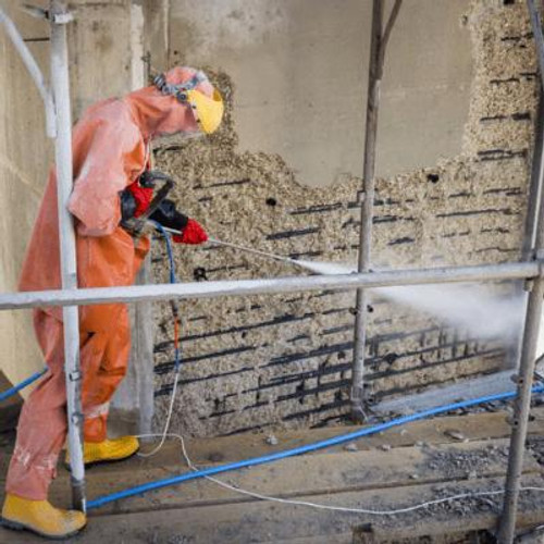 Person wearing full protective clothing and full face mask using a high pressure water on concrete.