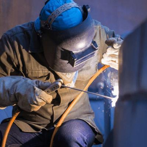 Person wearing welding helmet and gloves while welding