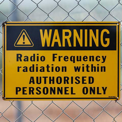 A warning sign attached to a wire fence, warning of radio frequency radiation within the fenced area