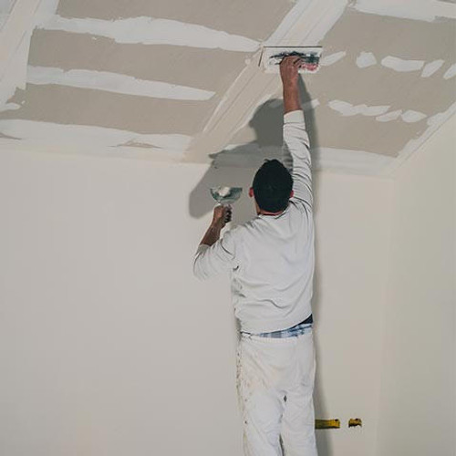 Worker filling in plasterboard