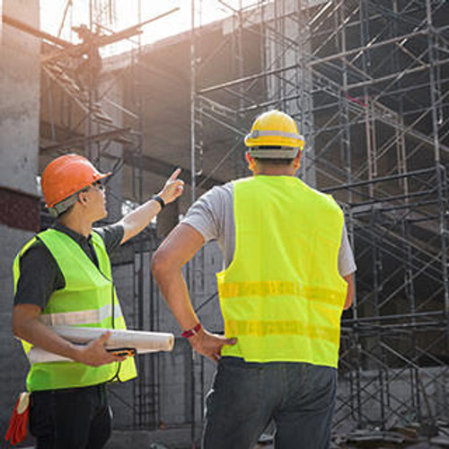 Engineer discussing with foreman about project in building construction site.