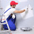 Man painting a wall with a roller, ladder and protective clothing.