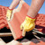 Worker with yellow gloves replacing red tiles or shingles on house