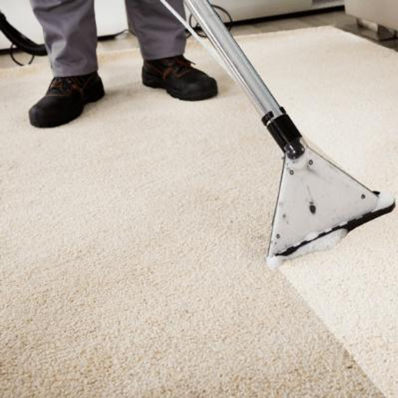 Person using a carpet cleaning wet vacuum to clean cream coloured carpet