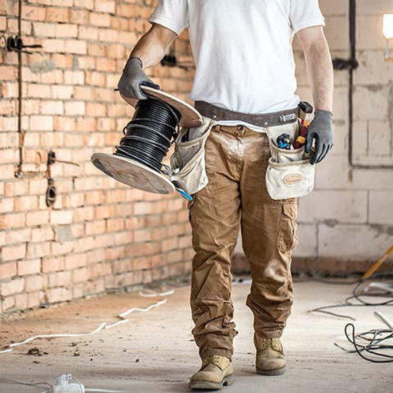 Man carrying cables conducting electrical renovations