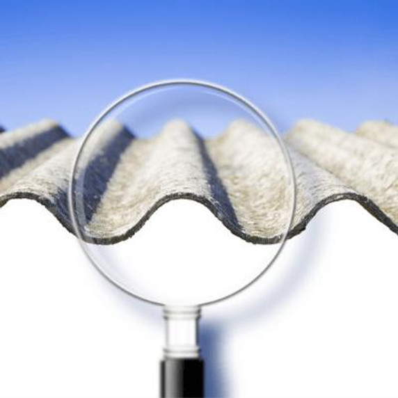 magnifying glass inspecting a sheet of asbestos.