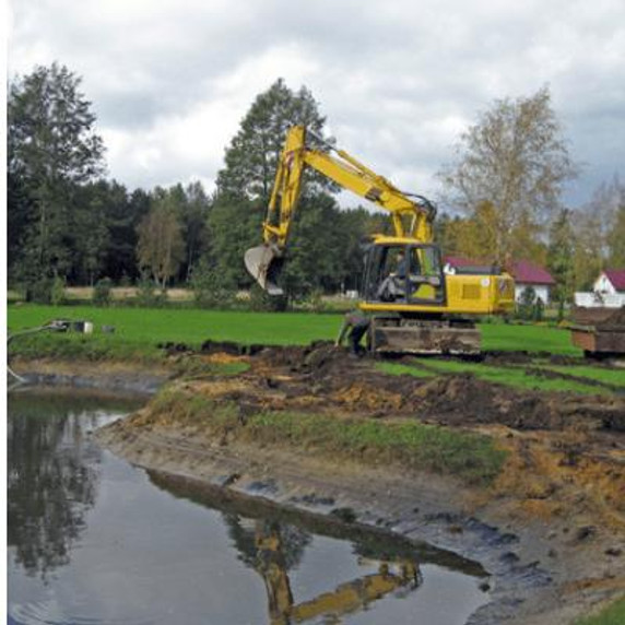 Digger working near pond.