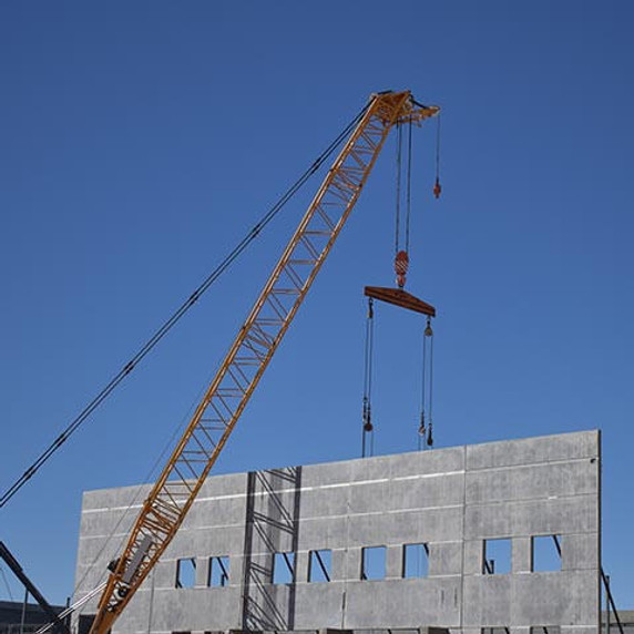 Crane lifting concrete wall panels into place