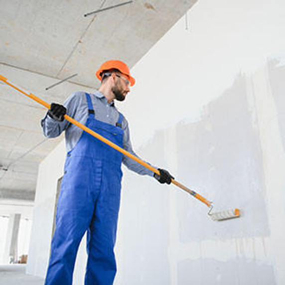 Painter painting wall on construction site